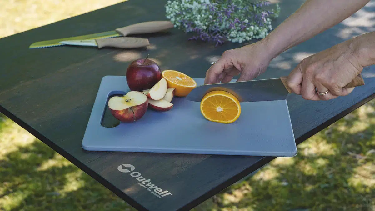 Outwell Caldas knife set with matching cutting board, featuring stainless steel knives and a wooden board for kitchen use.