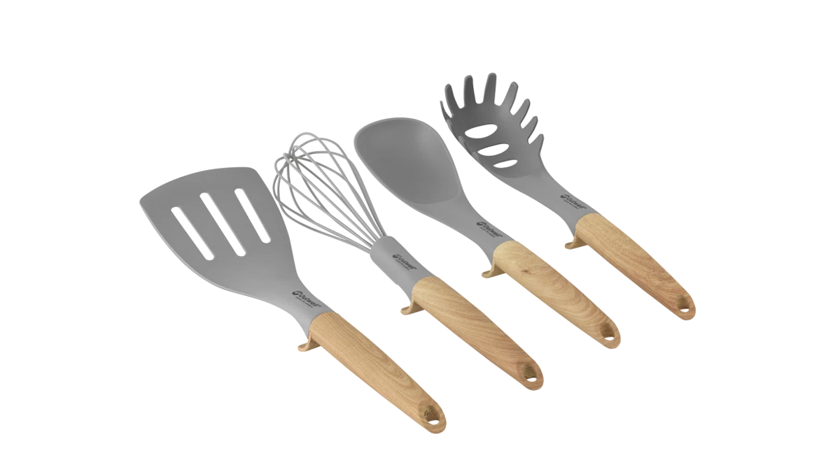 Outwell Almada kitchen utensil set with wooden handles, including spoons, spatulas, and tongs, arranged on a wooden surface.